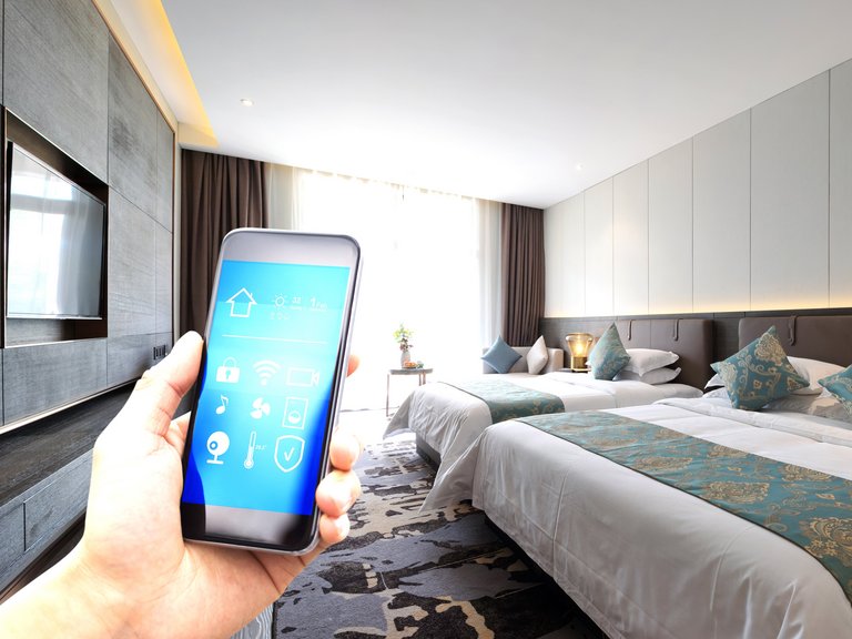 Gast mit Smartphone im Hotelzimmer